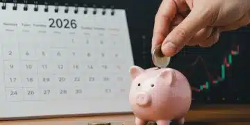 Hand placing coin into piggy bank, 2026 calendar, symbolizing retirement savings growth